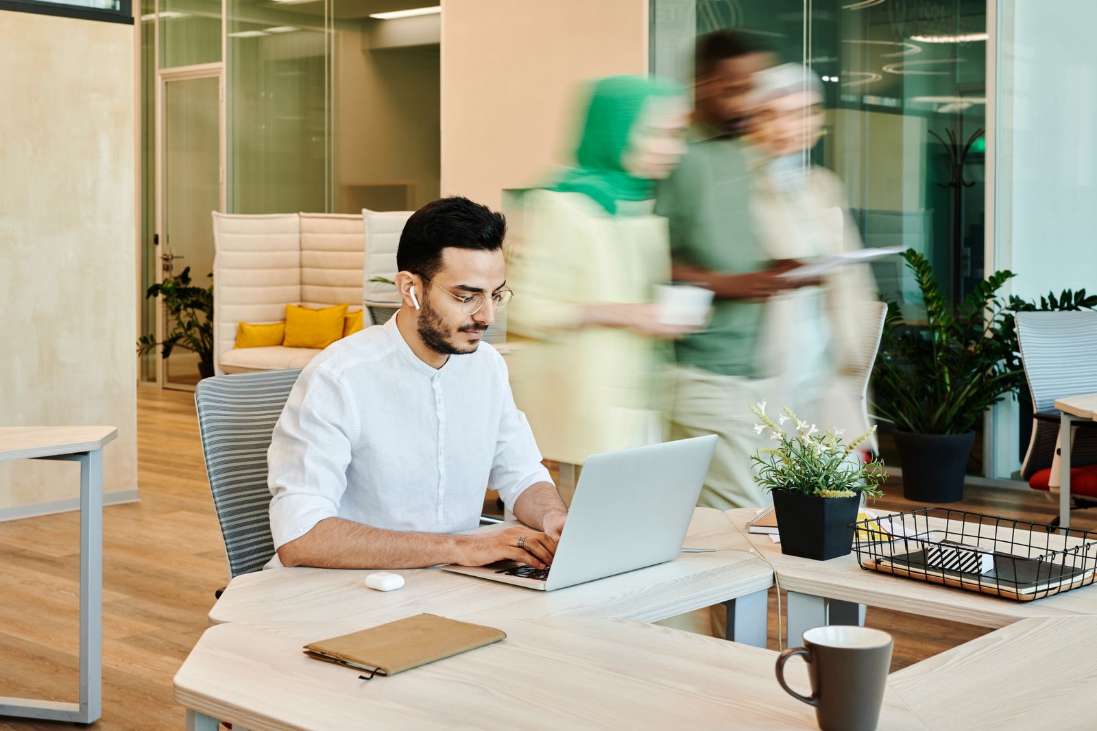 A professional using a laptop in a bright modern workplace