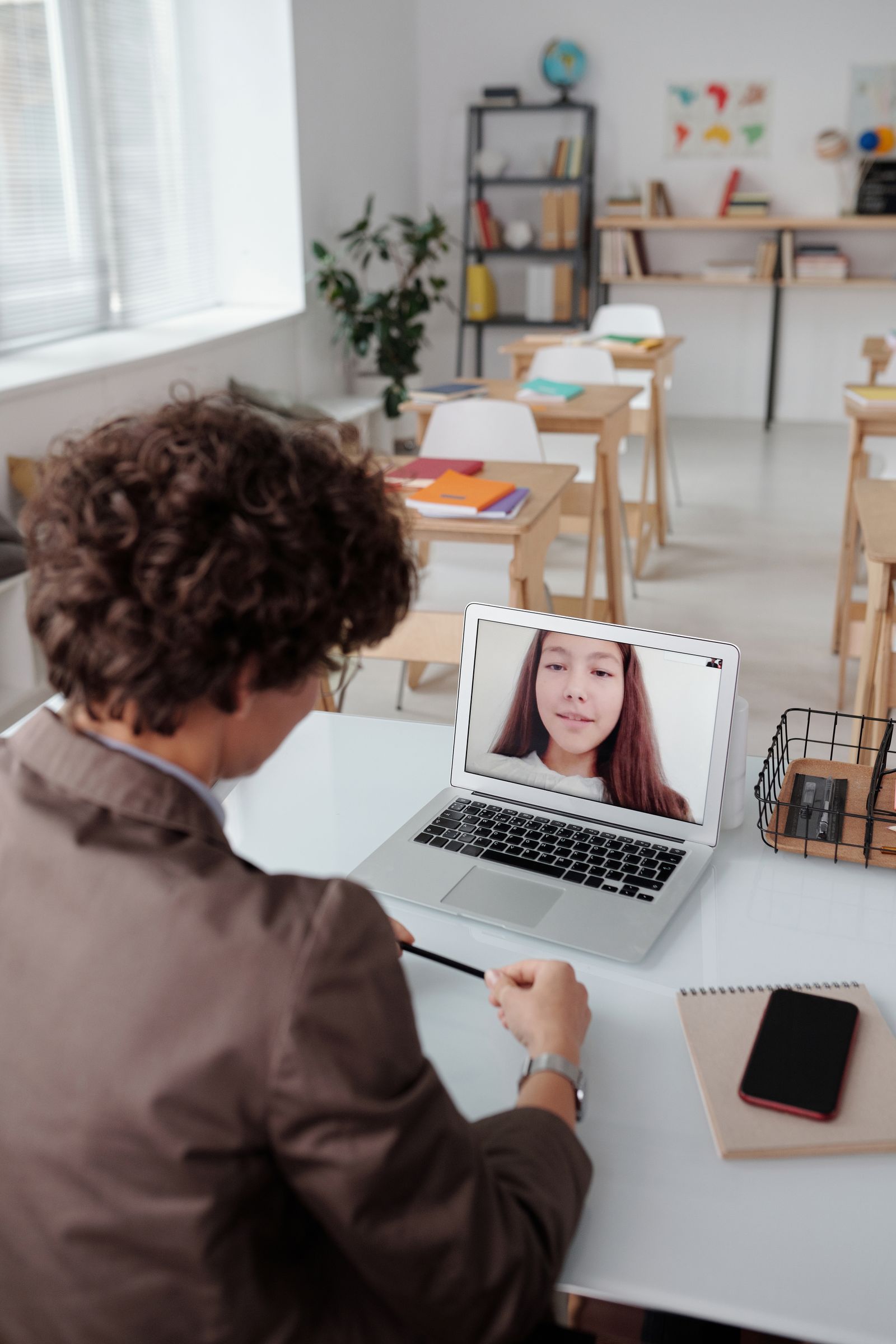 A teacher guiding a student through an online lesson
