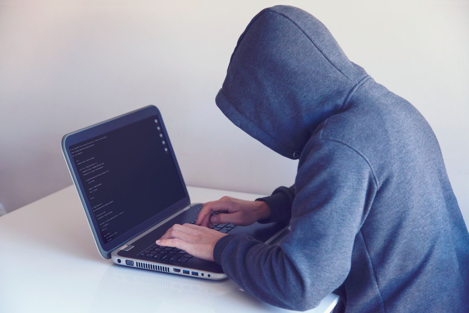 A person working privately on a laptop with code on screen